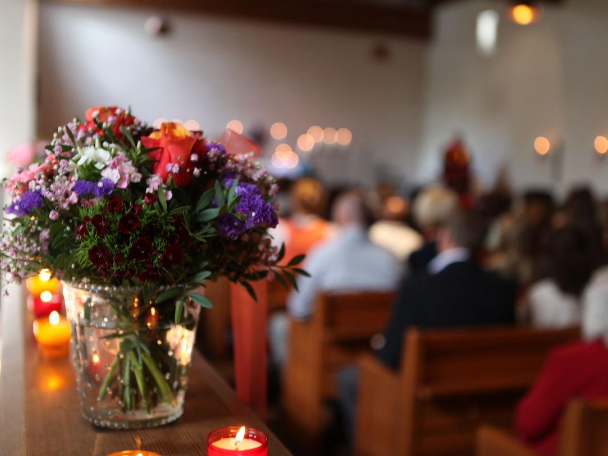 Gottesdienst in der Kirche mit Blumenstrauß im Vordergrund